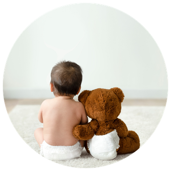 Bébé avec un nounours à côté